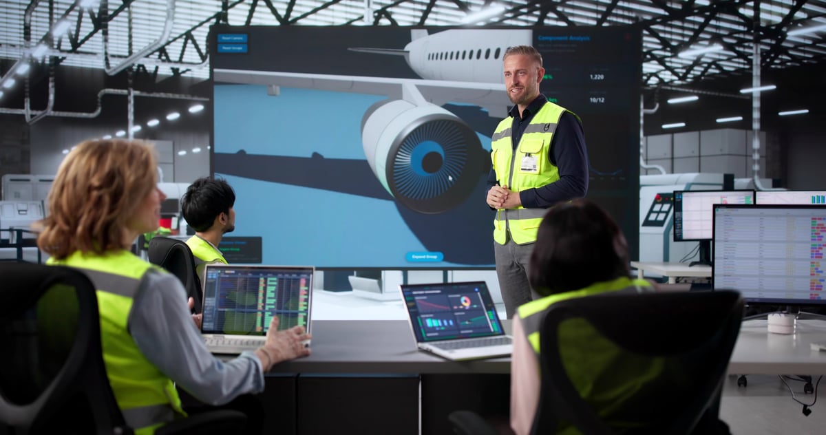 Flight department manager and pilots conducting a safety risk assessment around a conference table with operational manuals, digital risk matrix, and SMS dashboards