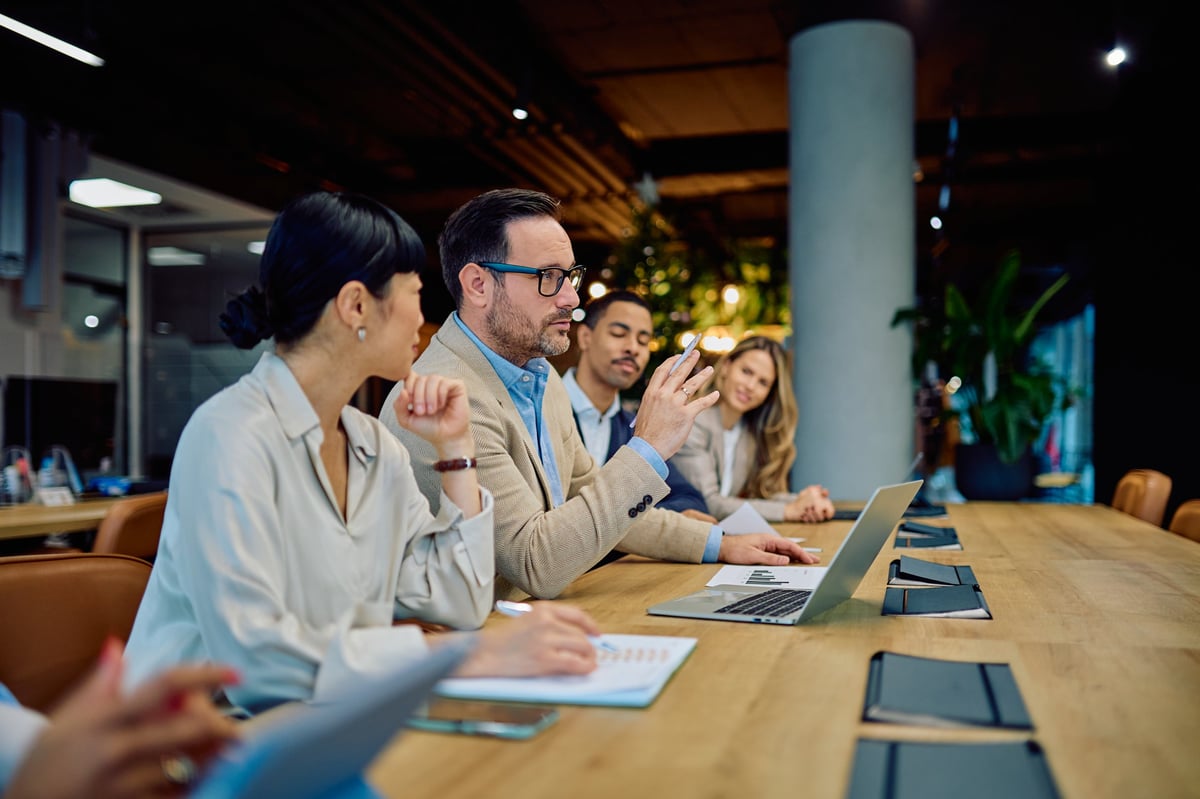 Business professionals engaging in a strategic meeting, discussing strategy and collaboration in a modern office setting